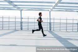 Man running on bridge in dark clothes 5QdYN0
