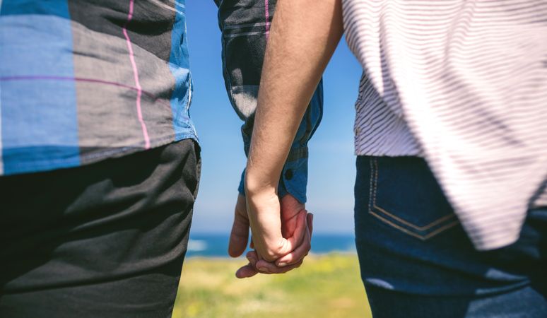 Unrecognizable couple holding hands