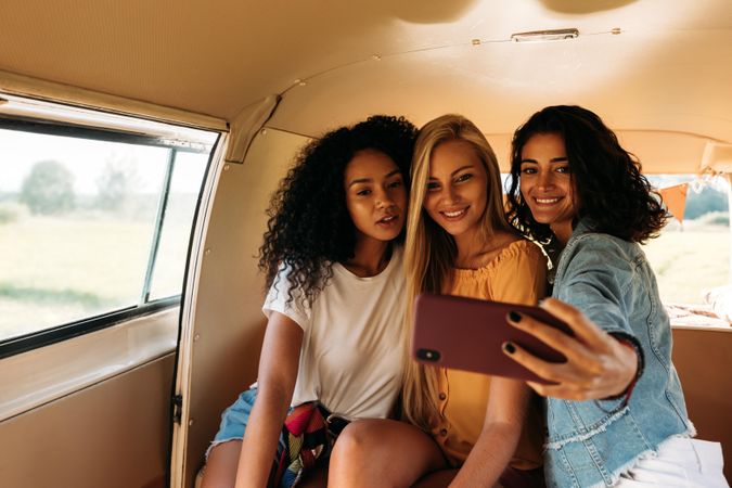 Three women taking a selfie in the back of a van