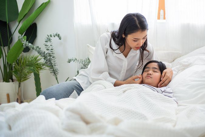 Woman comforting child as he goes to sleep
