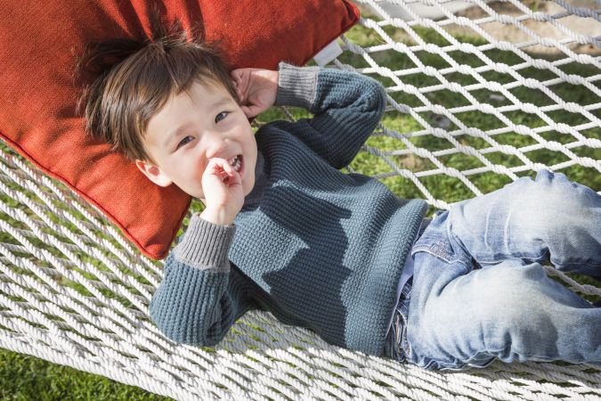 Sweet Biracial Young Boy Relaxing in Hammock