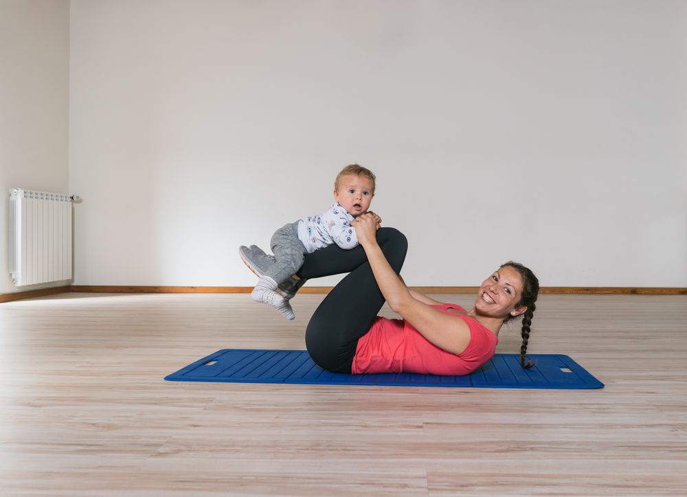 Mother exercising with baby in gym