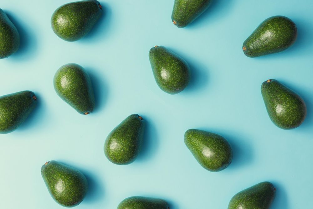 Whole avocado pattern on a pastel blue background