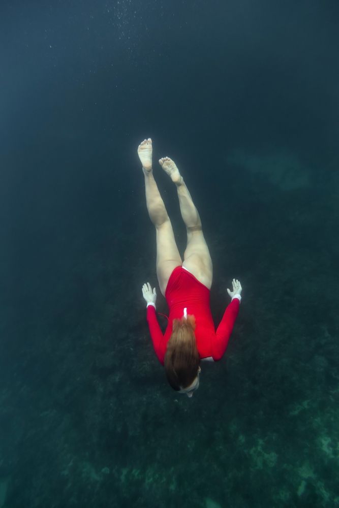 Woman diving in blue clean water