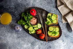 Top view of bread with cucumber slices, tomatoes and Himalayan salt