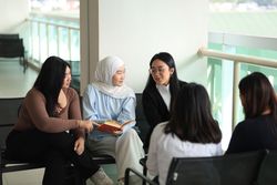 Portrait of Smart Asian University Students Woman Discussing Reading Books Together in  Campus
