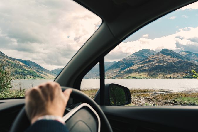 Driver in car with amazing landscape of mountains