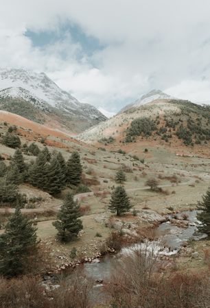 Wonderful valley with trees and high hills in cloudy weather
