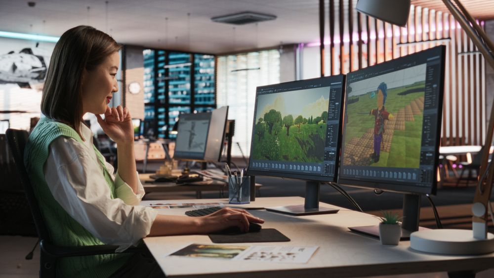Female Asian Game Designer Using Desktop Computer, Designing Unique World And Characters In 3D modelling Software For RPG Video Game.