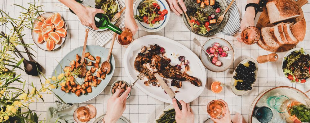 Flat-lay of hands of people eating and wine being poured