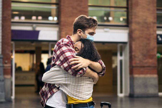 Young couple hugging at the station after a trip