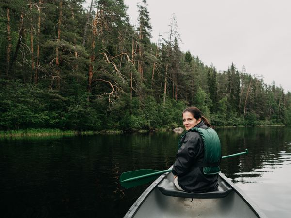 Woman boating on forest river in Finland