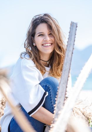 Young woman sitting near dried plants