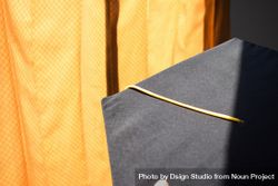 Top view of graduation cap with yellow tassel on yellow material background 5oDq2m