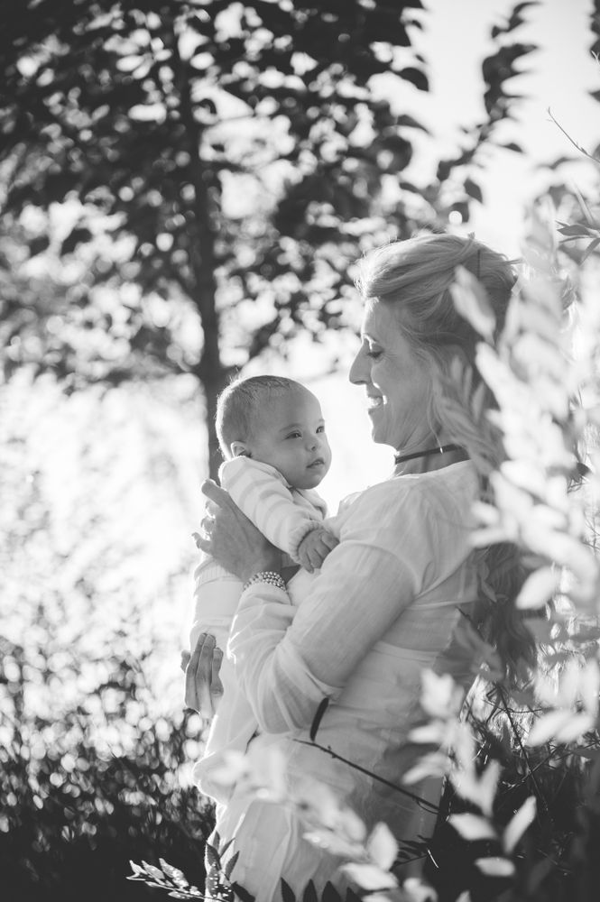 baby with down syndrome in the arms of his grandmother
