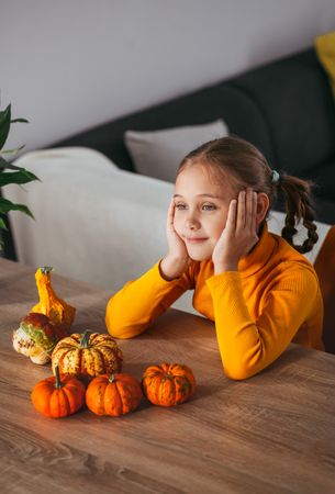 Little Girl Playing With a Pumpkin