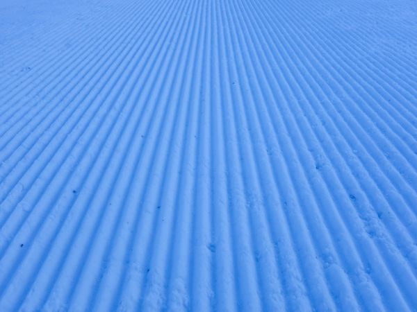 Ski slope grooves and ridges made by snow groomer