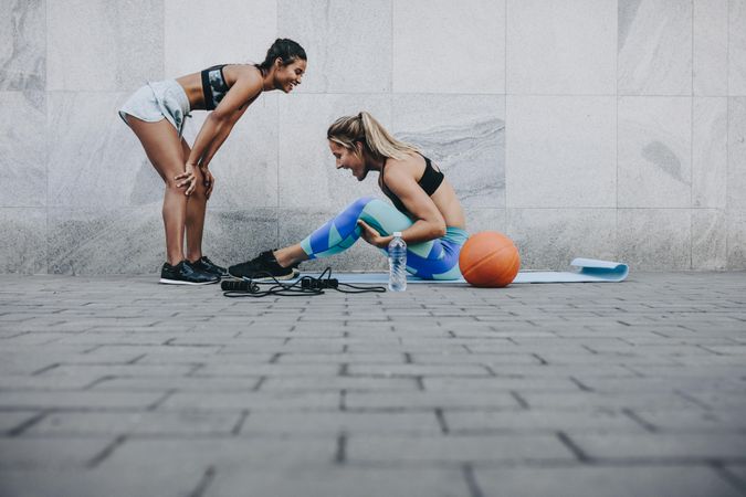 Two fitness women in happy mood while training outdoors