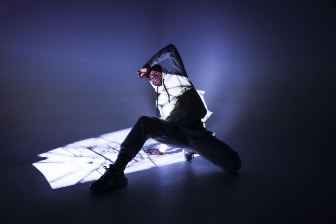 Black man dancing under bright light