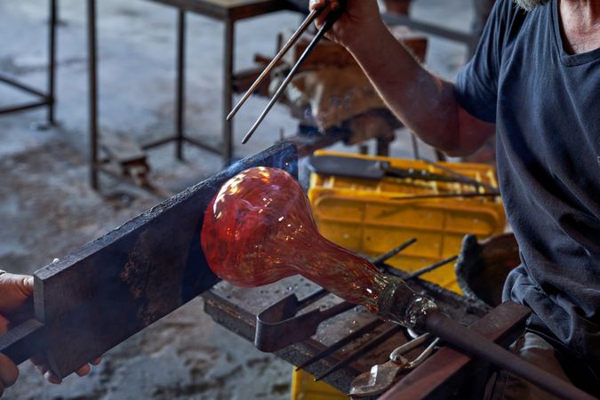 Crop worker cutting metal in workshop