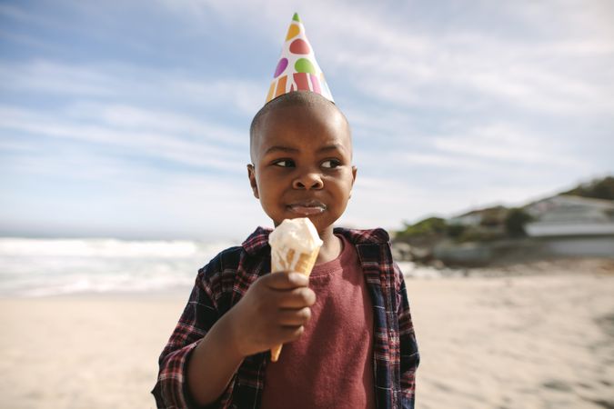 Birthday boy having ice cream in the sea shore