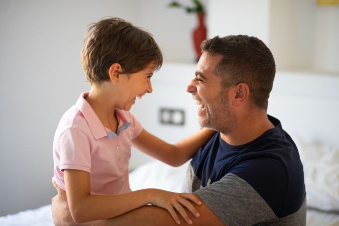 Little girl and dad smiling at each other at home