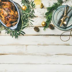 Roast chicken, table setting, decorations of fir, on a light background, square crop, copy space