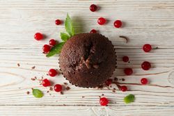 Chocolate muffin and berries on wooden background