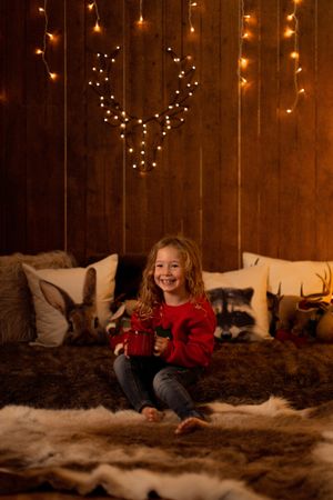Little girl with mug surrounded by christmas decoration