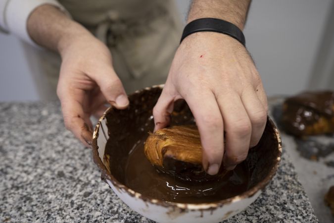 Confectioner decorating freshly baked croissants