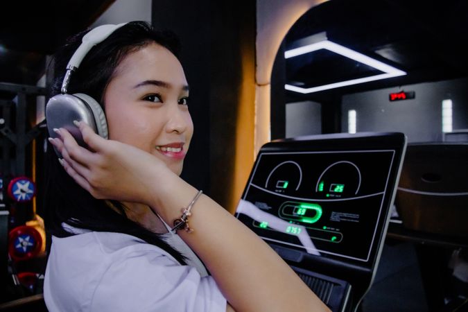 Serene woman using modern elliptical, fitness ambiance in studio