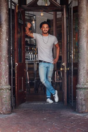 Stylish young man at a cafe front door