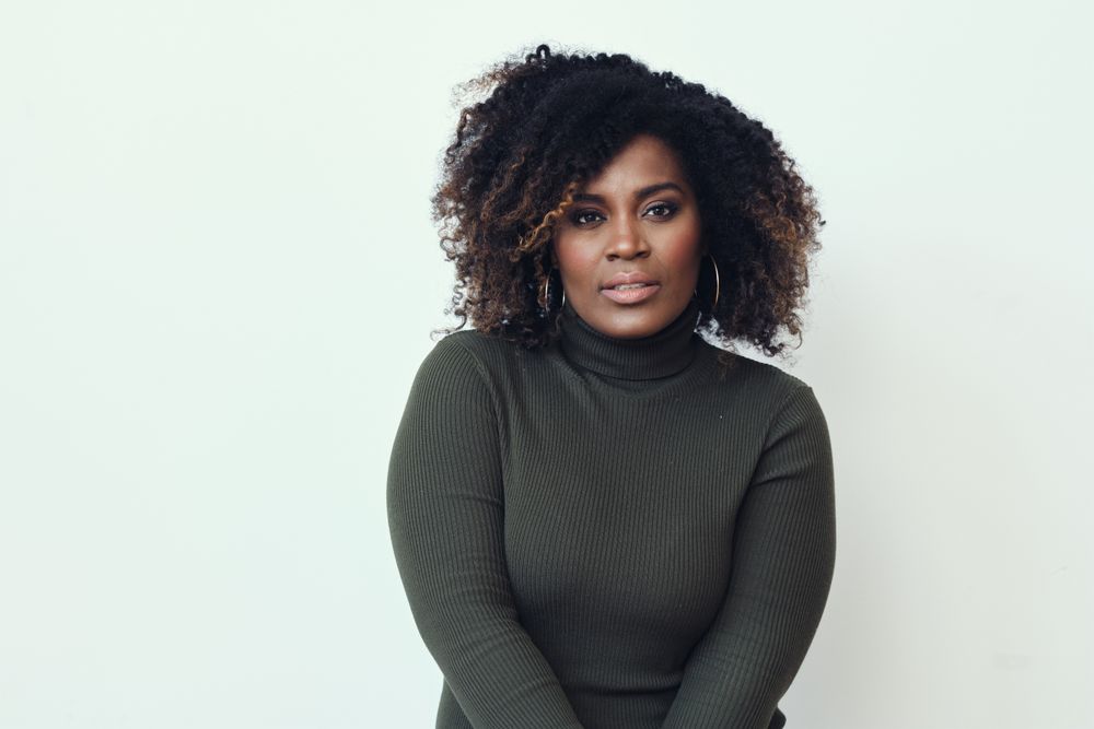 Portrait of serious Black woman in green turtleneck