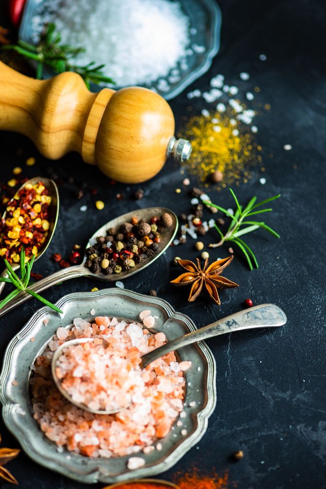 Spices and salt on dark counter