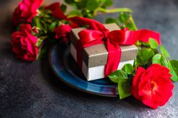 Table setting with red rose and present