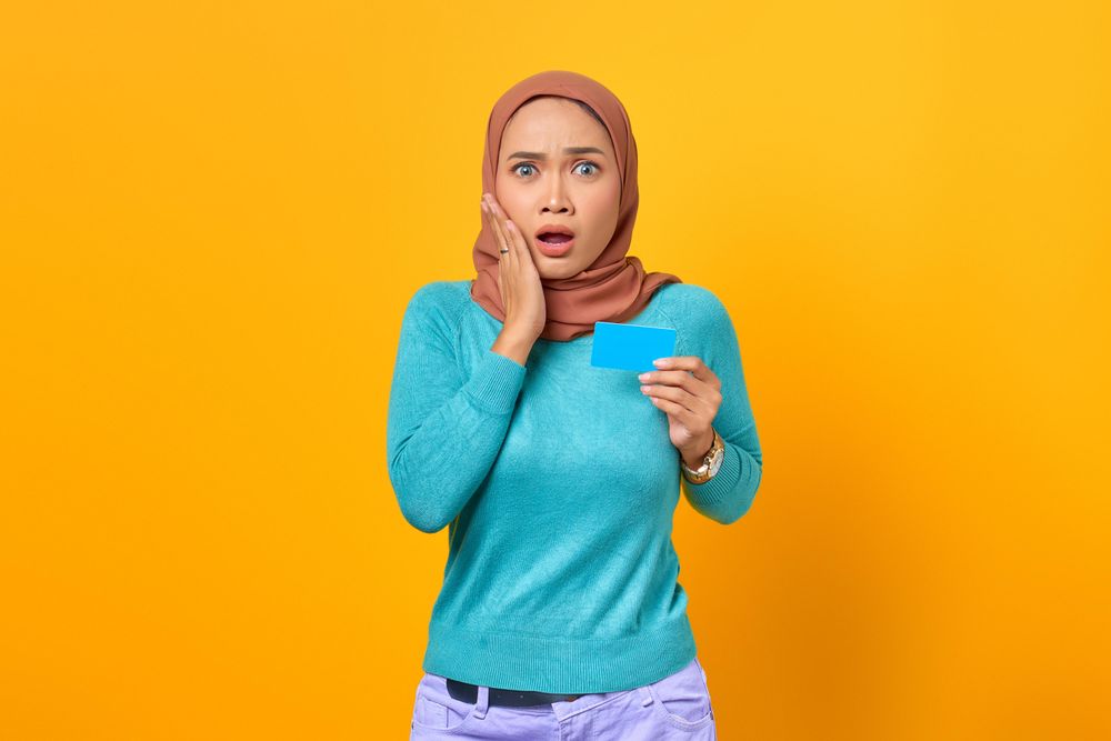 Muslim woman surprised and holding credit card