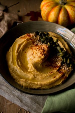 Dried leaves and napkins near pumpkin hummus