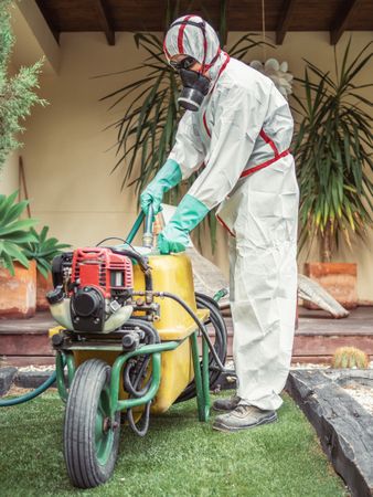 Fumigator pulling treatment hose from machine in yard