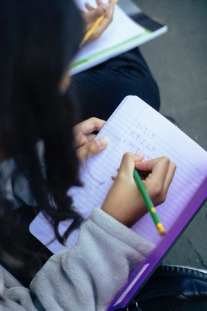 Close-up shot of girl writing in a notebook