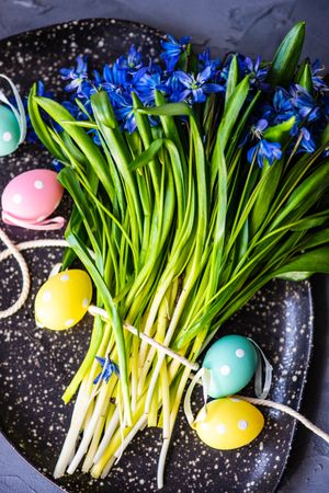Easter table setting with pastel eggs and scilla blue flowers