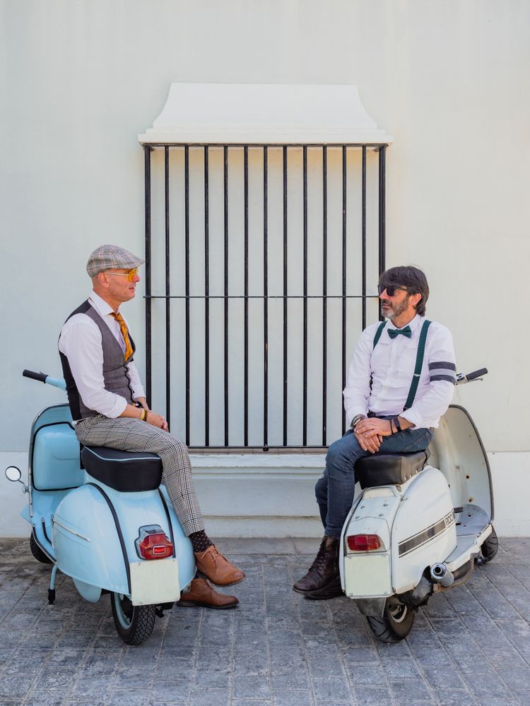 Trendy men sitting on vintage scooters