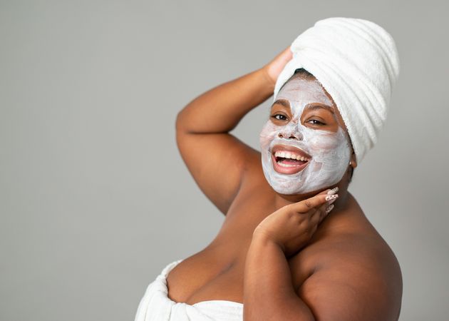 Cheerful Black woman with mud mask