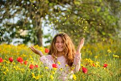 Delighted girl throwing petals in air