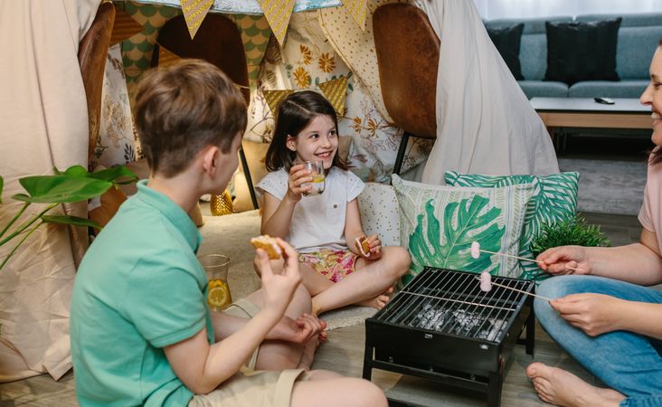 Family camping at home roasting marshmallows