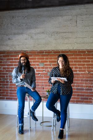 Man and woman public speaking in an exposed brick room