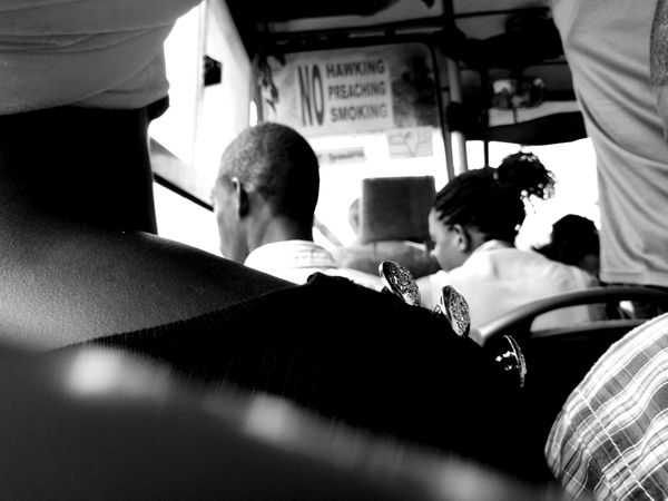 Back view of people in public transport in grayscale