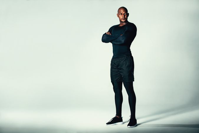 Fit man in sportswear with his arms crossed in studio