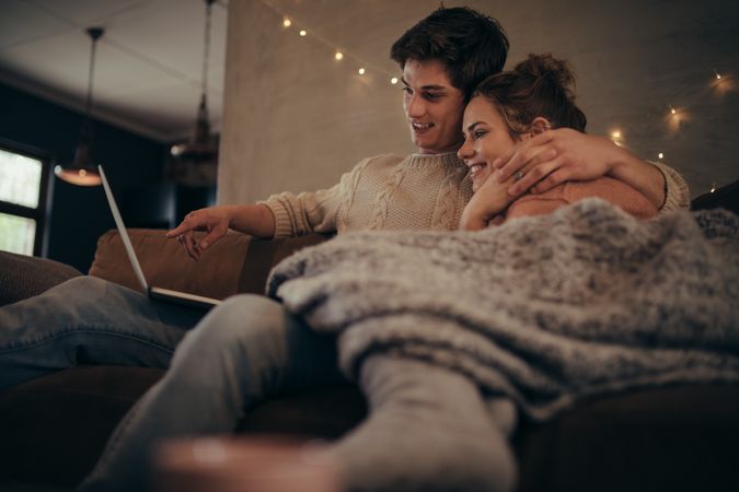 Loving couple in house with laptop