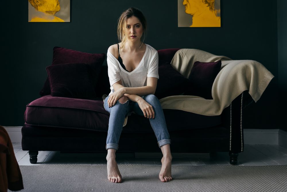 Young woman sitting on sofa in stylish room
