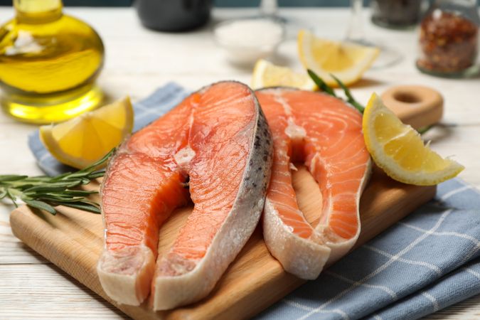 Composition with salmon meat and spices on wooden background, close up